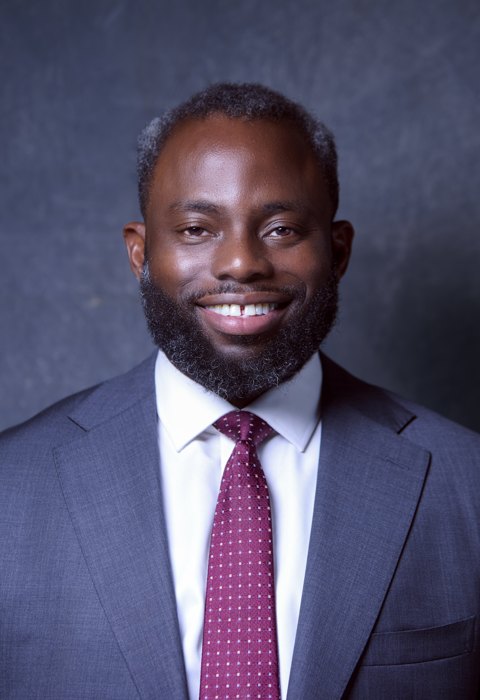 Headshot: navy suit, smiling close-up